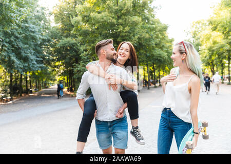 Happy amici passeggiando insieme in un parco Foto Stock