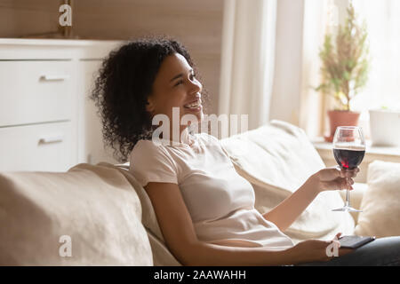 Sorridente americano africano donna rilassarsi su comodi divani Foto Stock