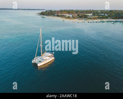 Drone shot di catamarano sul mare a Isola Gili-Air contro il cielo chiaro durante il tramonto, Bali, Indonesia Foto Stock