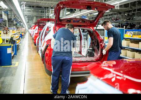 Due colleghi impegnati nella moderna fabbrica di automobili Foto Stock