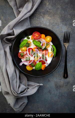 Formaggio con un vivace cocktail pomodori, cipolla rossa e pesto Foto Stock