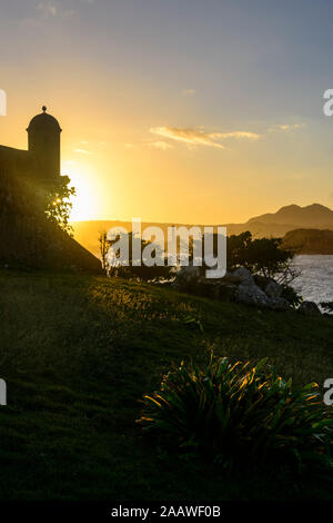 Silhouette torre di avvistamento di Fortaleza San Felipe contro il cielo al tramonto, Puerto Plata, Repubblica Dominicana Foto Stock