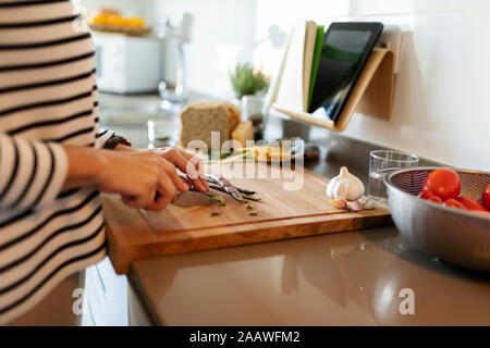 Close-up della donna per la cottura in cucina a casa il taglio di vegetali Foto Stock