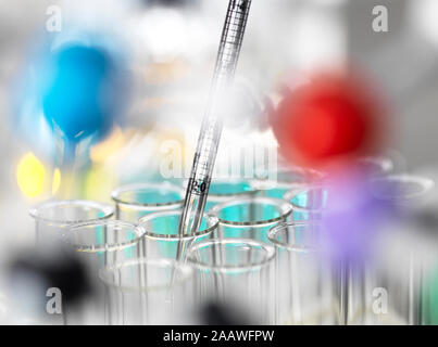 Campioni chimici il pipettaggio in tubi di prova per esperimenti in laboratorio Foto Stock