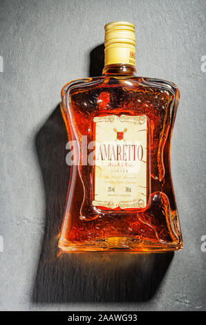 Bottiglia di liquore all'Amaretto su pietra ardesia sfondo. Amaretto proviene da Saronno in Italia Foto Stock