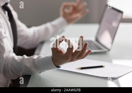 Ravvicinata di un dipendente di sesso maschile meditando a scrivania Foto Stock