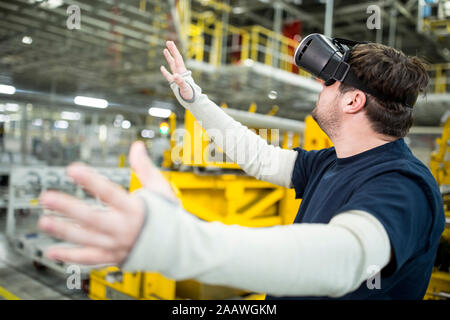Uomo che indossa gli occhiali VR nel moderno stabilimento Foto Stock
