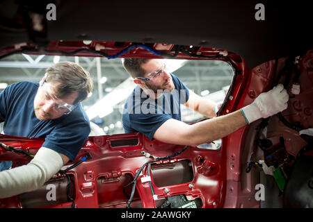 Due colleghi lavorano a carrozzeria nella moderna fabbrica di automobili Foto Stock