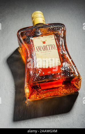 Bottiglia di liquore all'Amaretto su pietra ardesia sfondo. Amaretto proviene da Saronno in Italia Foto Stock