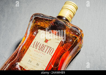 Bottiglia di liquore all'Amaretto su pietra ardesia sfondo. Amaretto proviene da Saronno in Italia Foto Stock