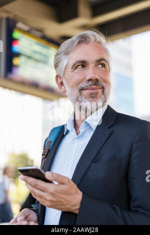 Ritratto di coppia imprenditore con telefono cellulare alla stazione Foto Stock