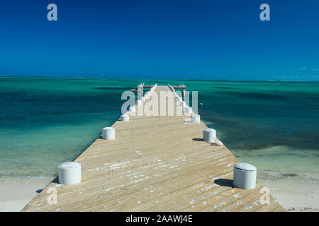 Una diminuzione del punto di vista del molo su mare contro il cielo blu e chiaro durante la giornata di sole, Providenciales, Turks And Caicos Islands Foto Stock