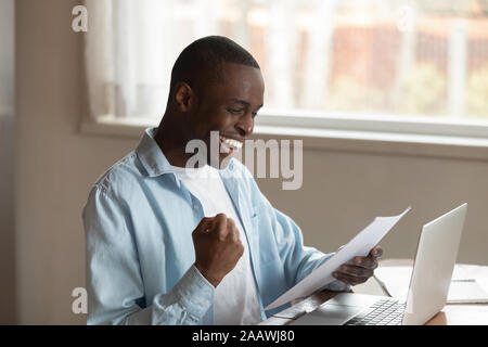 Felice African American uomo eccitato con buone notizie lettera Foto Stock
