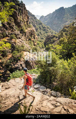 Escursionista femmina durante la camminata, Gorges de Spelunca, Ota Corse-du-Sud, Corsica, Francia Foto Stock