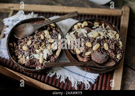 Angolo di alta vista di gelato al cioccolato con frutta e noci servita nel vassoio sul tavolo Foto Stock