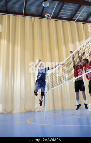 L'uomo jumping durante una partita di pallavolo Foto Stock