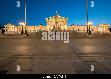 Esterno del illuminato austriaco edificio del Parlamento europeo a Vienna contro il cielo blu e chiaro di notte Foto Stock