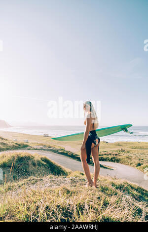 Giovane biondo surfer presso la spiaggia di Sopelana, Spagna Foto Stock