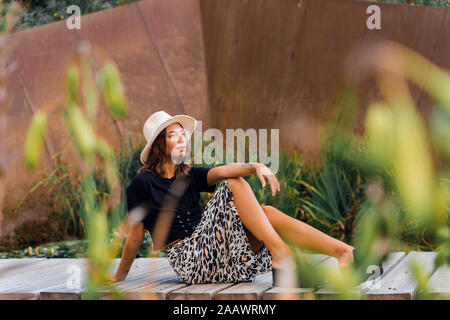 Ritratto di moda giovane donna rilassante sul Boardwalk Foto Stock