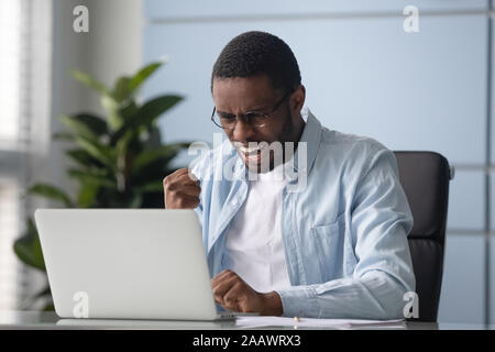 Emozionato African American uomo trionfo con buone notizie on line Foto Stock