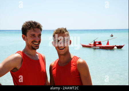 Ritratto di sorridere bagnini contro il bellissimo mare in una giornata di sole. Salento e Puglia, Italia Foto Stock