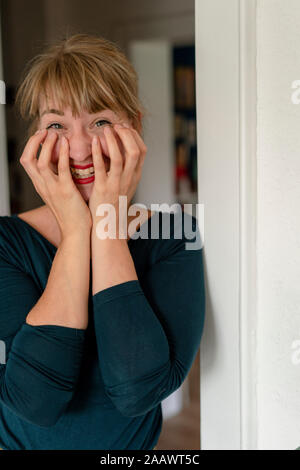 Ritratto di donna ridere a casa Foto Stock