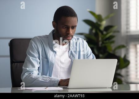 African American maschio di un dipendente che lavora sul computer portatile in ufficio Foto Stock
