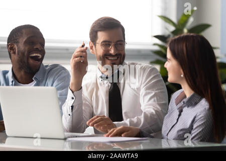 Overjoyed multietnica colleghi divertirsi a ridere di briefing Foto Stock