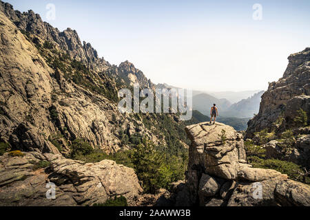 Escursionista femmina in piedi sul punto di vista, Aiguilles de Bavella, Corsica, Francia Foto Stock