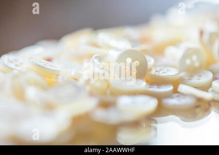 Close-up di pulsanti realizzati con conchiglie sulla tavola in officina Foto Stock