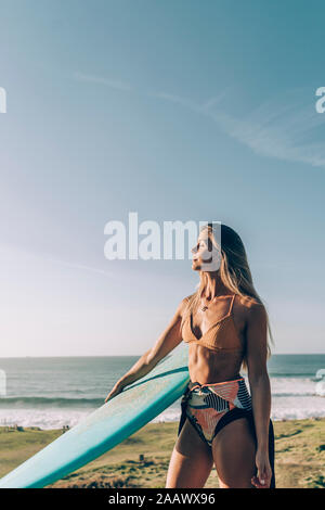 Giovane biondo surfer enjpying la luce del sole sulla spiaggia di Sopelana, Spagna Foto Stock