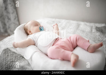 Carino bambina dorme sul letto Foto Stock