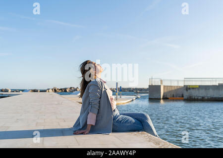 Giovane donna in un momento di relax a luce solare, Barcellona, Spagna Foto Stock