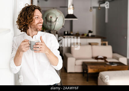 Uomo felice di bere il caffè a casa Foto Stock