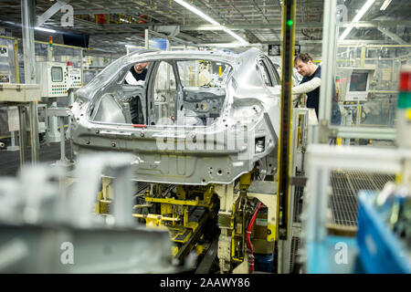 Due colleghi impegnati nella moderna fabbrica di automobili Foto Stock