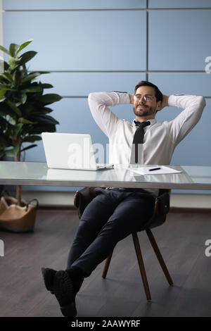 Maschio rilassato riposo dei dipendenti nella sedia la visualizzazione Foto Stock