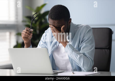 Stanco americano africano dipendente maschio soffrono di mal di testa Foto Stock