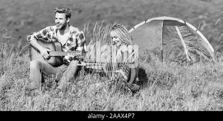 Escursionismo romance. Campeggio in montagna. Aria fresca e sentimenti puri. Matura in amore felice natura rilassante sfondo. Ragazzo ragazza chitarra vicino camping tenda. La vacanza estiva. Vacanza in campeggio. Foto Stock