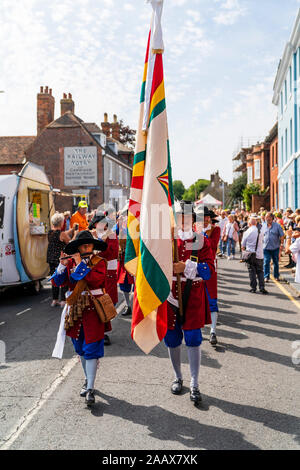 La Dutch Trommelfluit Marching Band lungo la strada principale durante la sfilata a Faversham Hop Festival. Vestito nel XVII secolo uniformi di colore arancione. Foto Stock