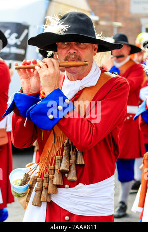 Uomo maturo flautista dall'olandese Trommelfluit Marching Band durante una parata a Faversham Hop Festival. Vestito nel XVII secolo uniformi di colore arancione. Foto Stock