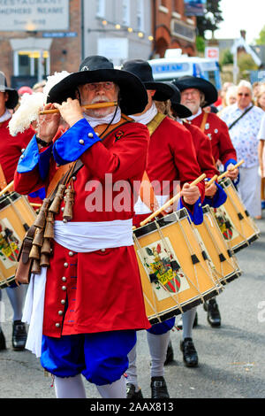 Uomo maturo flautista dall'olandese Trommelfluit Marching Band durante una parata a Faversham Hop Festival. Vestito nel XVII secolo uniformi di colore arancione. Foto Stock