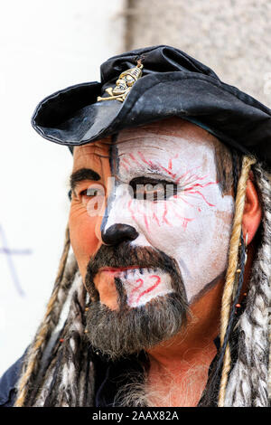 Uomo maturo dal Drumskullz drumming gruppo a Faversham Hop Festival.Close up della faccia metà coperti in bianco trucco, vestito come pirati. Foto Stock