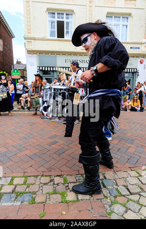 Uomo maturo dal Drumskullz drumming gruppo a Faversham Hop Festival. In street e vestito in costume di pirati e faccia bianca make up. Foto Stock