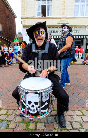 Uomo maturo dal Drumskullz drumming gruppo a Faversham Hop Festival. In street e vestito in costume di pirati e faccia bianca make up. Di fronte. Foto Stock