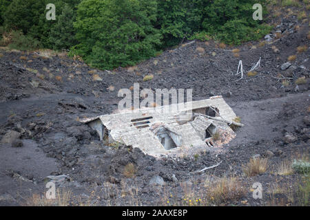 Casa coperte di lava sulle pendici del monte Etna, Sicilia, Italia Foto Stock