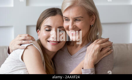 Sorridente pacifica i vecchi pensionati madre abbracciando la calma felice figlia. Foto Stock