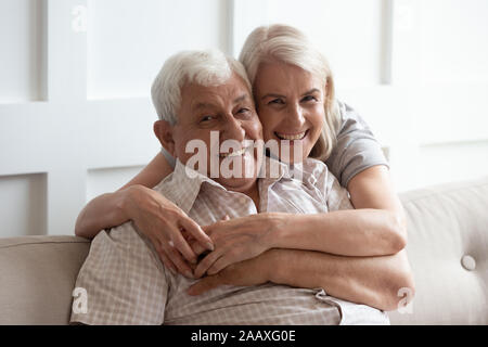 Bella donna di mezza età che abbraccia felice 80padre s. Foto Stock