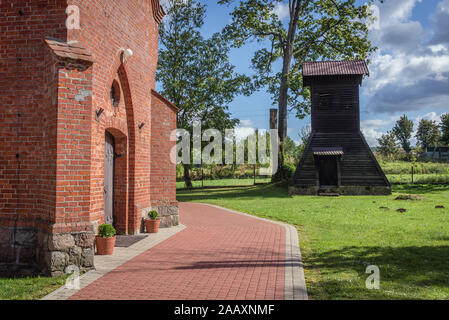 In legno torre campana accanto alla chiesa cattolica romana Natività della Beata Vergine Maria nel villaggio Glaznoty trova Ostroda contea di Polonia Foto Stock