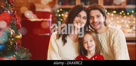 Allegro giovane famiglia in posa su cucina arredata Foto Stock