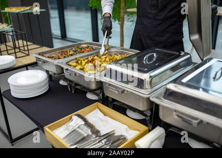 Tabella per banchetti con chafing dish riscaldatori. Molti buffet vassoi riscaldati presso il catering Foto Stock